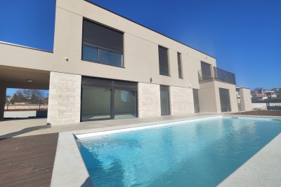 A modern villa with a pool in a new building